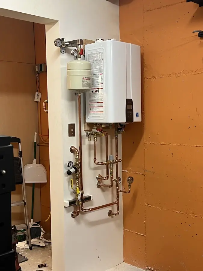 Plumbing technician inspecting water heater connections in Pacifica
